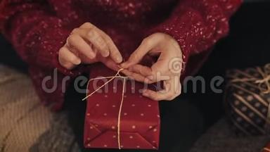 紧紧<strong>抓</strong>住女人的手，最后敲定圣诞红色礼物盒包扎胶带，并绑在<strong>蝴蝶</strong>结。 假期及假期概念